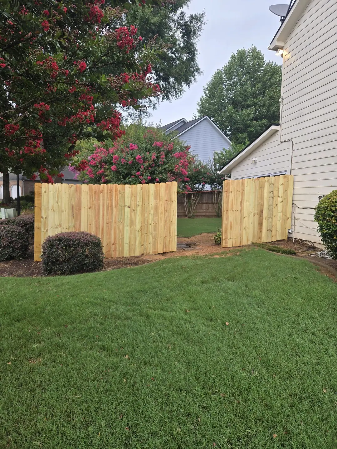 Build day: new pine fence panels framing the side yard opening