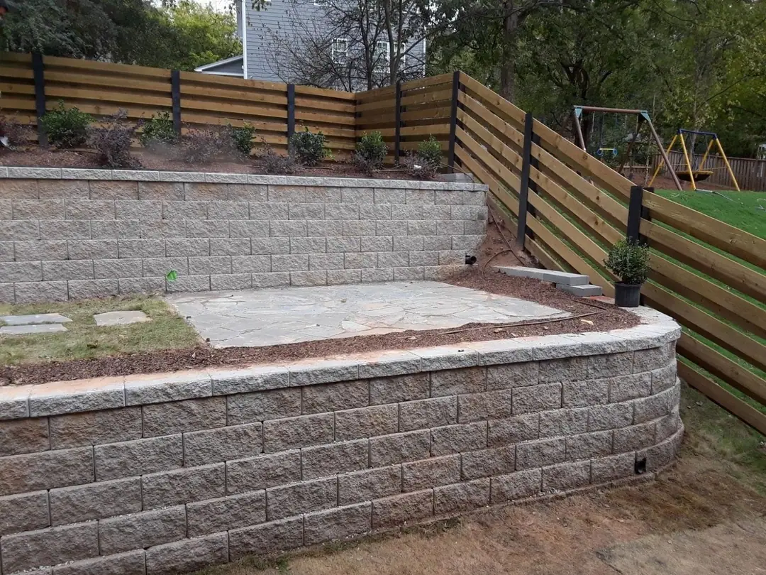 Horizontal fence stepping along a stone retaining wall